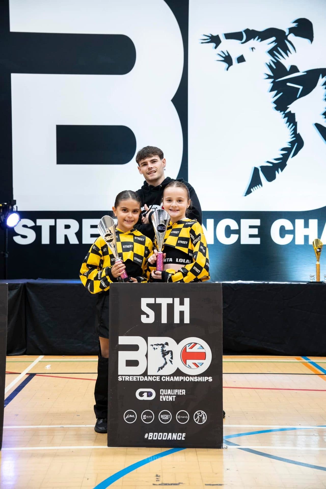 D2E Academy girls celebrating 5th place at the BDO Championships with their teacher